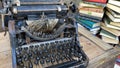 Vintage typewriter on a wooden table next to old books Royalty Free Stock Photo