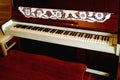 Vintage Upright Piano with an Empty Stool in Foreground