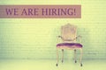 Vintage vacant chair on brick wall. Vacancy concept. We are hiring message