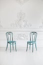 Vintage viennese chairs against the wall with a bas-relief of plaster stucco. Selective focus Royalty Free Stock Photo