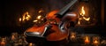 Vintage violin in front of a burning fireplace with candles on the background Royalty Free Stock Photo