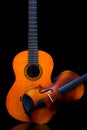 Vintage violin and wooden guitar on dark background