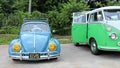 A vintage Volkswagen Beetle and VW minibus sit side by side on display. Royalty Free Stock Photo