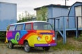 A vintage Volkswagen (VW) camper van painted with psychedelic hippy colors