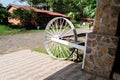 Vintage wagon wheel leaning against a rustic stone building in a rural outdoor setting Royalty Free Stock Photo