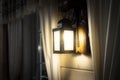 Vintage wall lamp with shining on light bulb decorated in dark wooden house Royalty Free Stock Photo