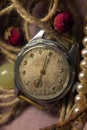 vintage warm color still life with old metal soviet vintage watch, rose flowers, pink fabric and pearl beads
