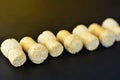 Diagonally lined seven sparkling wine corks on black background.