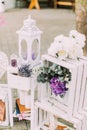 Vintage wedding composition. White crate decorated with colourful flowers, candle stand and books.