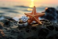 vintage wedding rings inside a starfish shell, placed on a coastal rock at sunset