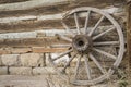 Vintage wooden wagon wheel weeds western log stone wall