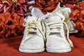 Vintage white baby shoes on red with flowers