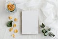 Vintage white background and blank postcard - white background, yellow roses, eucalyptus sprig and copy space.