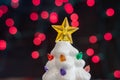 Vintage white ceramic Christmas tree, focus only on the star tree topper, with red bokeh background Royalty Free Stock Photo