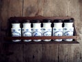 Vintage white ceramic storage jars, used for spices on rustic wood background. Every jar has the name of a spice in italian