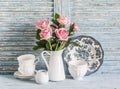 Vintage white crockery and rose bouquet on blue wooden background. Kitchen still life in vintage english country style. Flat lay Royalty Free Stock Photo