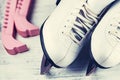 Vintage white female skates for figure skating, on a light wooden background. Royalty Free Stock Photo