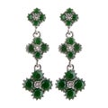 Vintage white gold or silver earrings with green gemstone. Royalty Free Stock Photo