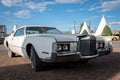 Vintage white Lincoln Continental Mark IV car parked in front of a wigwam motel