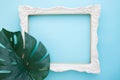 Vintage white picture flame and monstera leaf on blue color back