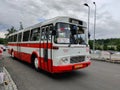 A vintage white and red Karosa L11.1310 bus navigating its scenic route from Loket to Karlovy Vary