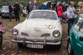 Vintage white rusty VW Karman Ghia parked