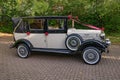 Vintage white wedding car with red ribbons