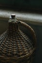 Vintage wicker wine bottle near the window Royalty Free Stock Photo