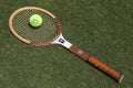 Vintage Wilson Cris Evert tennis racket and Slazenger Wimbledon Tennis Ball on the grass tennis court.