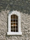 Vintage window with massive white stone blocks frame with lighting candle chandelier inside front view Royalty Free Stock Photo