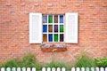 Vintage window with shutters that open and fresh flowers with colored glass and brick wall Royalty Free Stock Photo