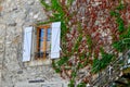 Vintage window on the stone wall with dry and green ivy plant growing around in a mountain village near Lescun, France. Tranquil Royalty Free Stock Photo