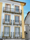 Vintage windows on the exterior facade of white and yellow in the historic centre of Evora, Portugal. Authentic portuguese