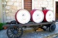 Vintage wine barrels on an old horse wagon in front of an old stone house Royalty Free Stock Photo