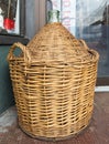 Vintage Wine Bottles in wicker basket on a barrel. Antique empty wicker wine bottle Royalty Free Stock Photo