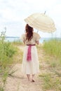 Vintage woman with parasol at the beach