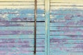 Vintage wood background with peeling turquoise and yellow old flaky paint and an old rusty pipe. wall of an old house Royalty Free Stock Photo