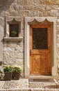 Vintage wood medieval door in rural stone wall house, Switzerlan