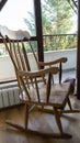 Vintage wood rocking chair on deserted old attic floor. Window and balcony to the street Royalty Free Stock Photo