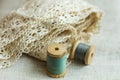 Vintage wood spools with green and grey threads on linen fabric, cotton lace, sewing hobby concept