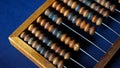 Vintage wooden abacus close up. Counting wooden knuckles. Part of the old end of the abacus on a dark blue background. Royalty Free Stock Photo