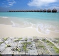 Vintage wooden board with sea, beach and lodges over water background