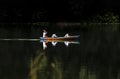 Traditional wooden boat passes silently in the tranquil lake environment