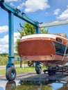 Vintage wooden boat in sling