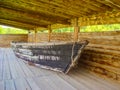 Vintage wooden boats under a canopy of round lumber