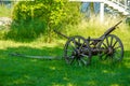 Vintage wooden carriage axle on green field Royalty Free Stock Photo