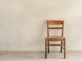 Vintage wooden chair against plain wall Royalty Free Stock Photo