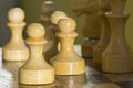 Vintage wooden chess on the chessboard. White pawns and other chess pieces close-up Royalty Free Stock Photo