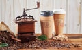 Vintage wooden coffee grinder with takeaway cups Royalty Free Stock Photo