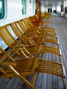 Vintage wooden cruise ship deck chairs sit empty Royalty Free Stock Photo